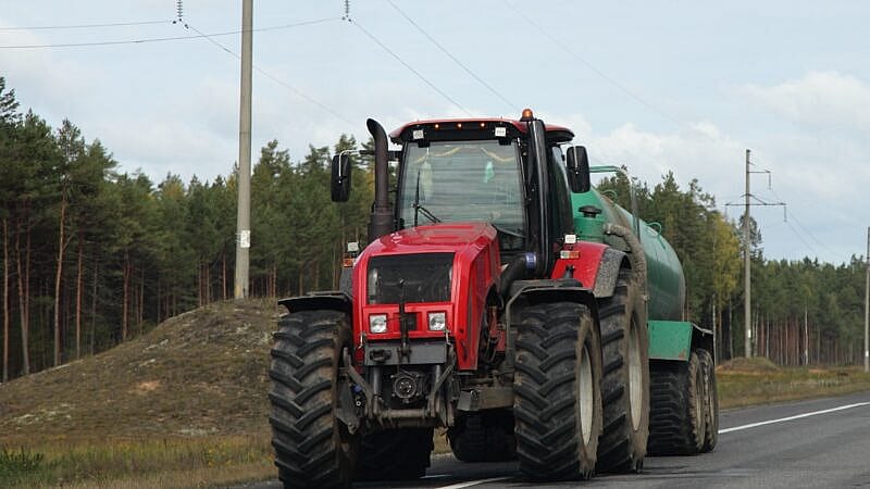 Big,Red,Wheeled,Tractor,With,Barrel,Drive,On,Country,Highway